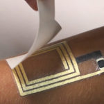 Elektronisk krets i bladguld appliceras på en arm.