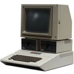 Datorn Apple II med bildskärm och två diskettstationer.