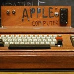 Apple I. Trälåda med tangentbord (som inte ingick i priset). På en panel bakom tangentbordet står det APPLE COMPUTER med ojämna bokstäver. Bildskärm saknas.